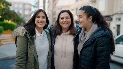 Mother and daugthers smiling confident hugging each other at street