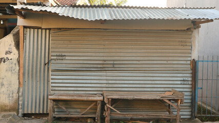 A simple old traditional shop (warung) building with corrugated iron as roof and door in Indonesia