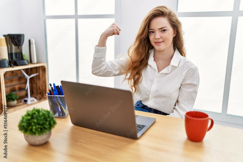 Poster young caucasian woman working at the office using computer laptop strong person showing arm muscle, 