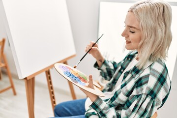 Young artist student girl smiling happy painting at art studio.