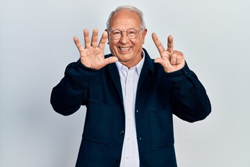 Senior man with grey hair wearing casual style and glasses showing and pointing up with fingers number seven while smiling confident and happy.