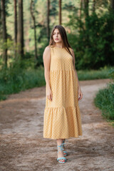 Lovely girl in yellow summer dress outdoors