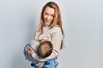 Young caucasian woman holding and hugging her son breastfeeding him, maternity lactation