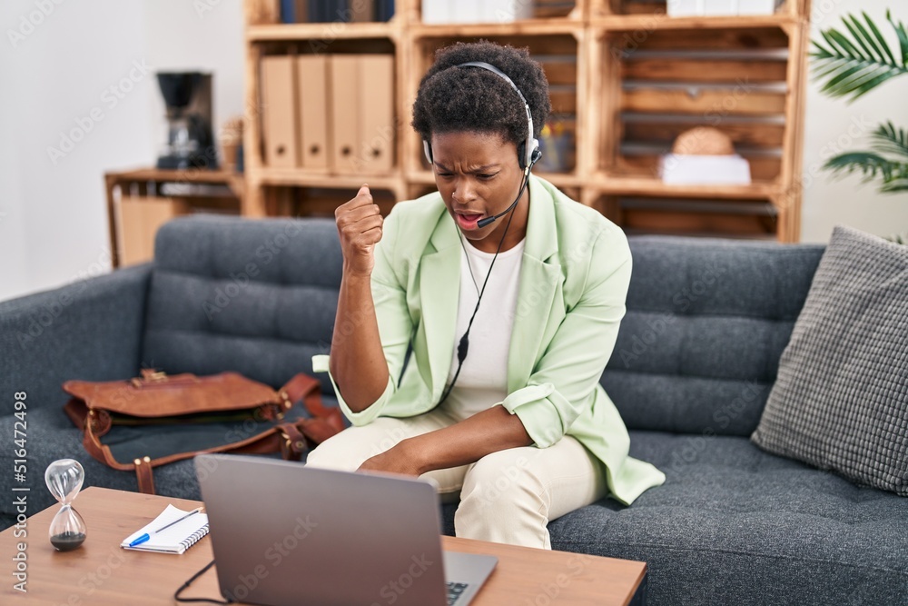 Wall mural African american woman doing online session at consultation office annoyed and frustrated shouting with anger, yelling crazy with anger and hand raised