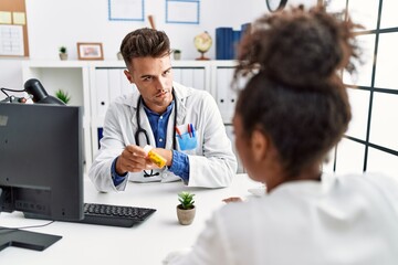 Man and woman wearing doctor uniform having medical consultation prescribe pills at clinic