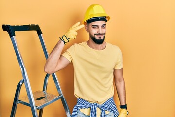 Handsome man with beard by construction stairs wearing hardhat shooting and killing oneself...