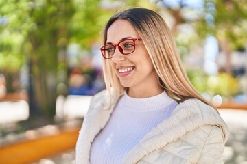 Young woman smiling confident wearing glasses at park