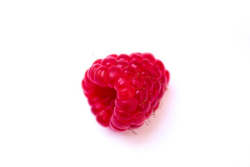 a red raspberry lies on a white background