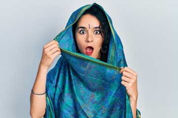Young woman wearing bindi wearing traditional indian saree smiling cheerful pointing with hand and...