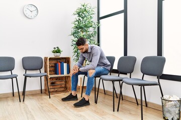 Young arab man desperate sitting on chair at waiting room