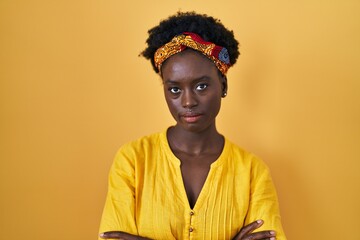 African young woman wearing african turban skeptic and nervous, disapproving expression on face with crossed arms. negative person.