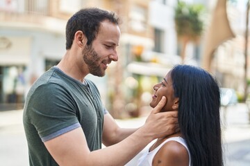 Obraz premium Man and woman interracial couple hugging each other at street