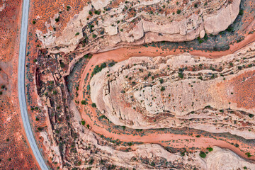 Top down drone photo of highway in Utah through red canyon and empty riverbed. 