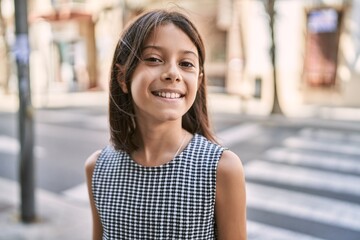 Young hispanic girl smiling outdoor at the town