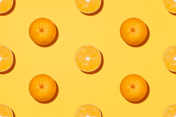 Oranges. Minimal photo in top view. Halves and whole of citrus fruits on yellow background. 