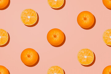 Orange fruit in top view. Halves and whole of oranges on pastel pink background