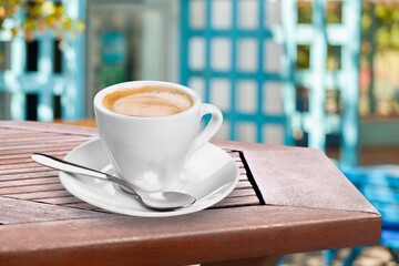 Ceramic cups of aromatic coffee with foam on the table in cafe