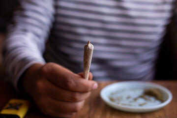 manos sosteniendo un blunt de marihuana (Cannabis). Concepto de medicina natural.