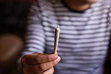 manos sosteniendo un blunt de marihuana (Cannabis). Concepto de medicina natural. © artrolopzimages