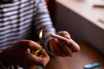 manos quemando un blunt de marihuana (Cannabis). Concepto de medicina natural. © artrolopzimages