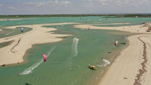 Numerous kite surfers playing in turquoise shallow Brazilian bay