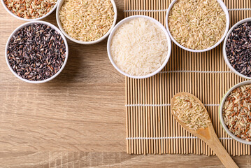 Thai rice seed (brown, white and purple) in bowl on wooden background, Table top view