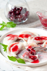 Hot dessert. Cherry dumplings with sweet sauce. Vegetarian food.