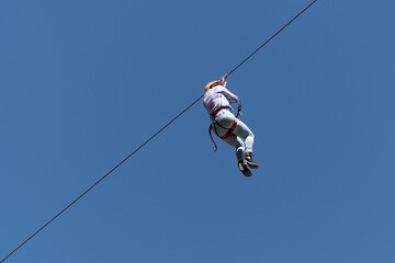 Person sliding down the zip line seen from below.