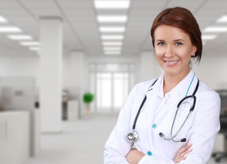Young happy doctor standing on hospital background