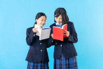 Obraz premium 本を読む制服を着た二人の少女 女子中学生