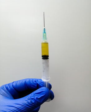 Scientist holding a syringe with vaccine, vaccination conceptual image.