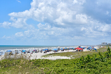 Fototapeta premium Cocoa Beach crowded with tourists and locals in summer on the space coast in Central Florida, Brevard county. 
