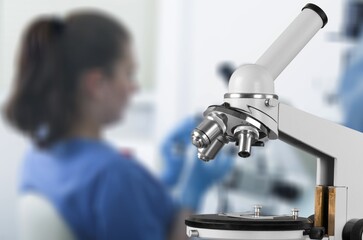 Professional laboratory microscope and scientists working in the background