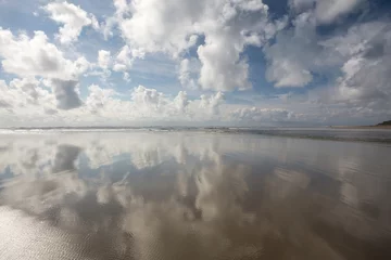 Vlies Fototapete Reflection Wolken, die sich im wasserbedeckten Sandstrand an der Ozeanküste spiegeln