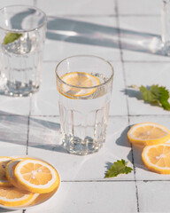 Fototapeta premium Fresh summer cocktail with lemons and mint. Summer drinks and vacation concept. Sunny day shadows
