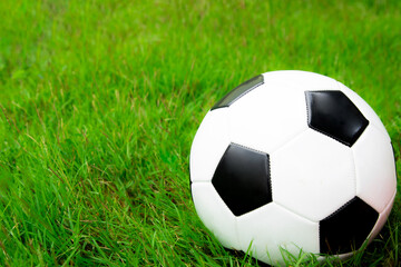 Fototapeta na wymiar Football ball on the green field close up. sport concept background.