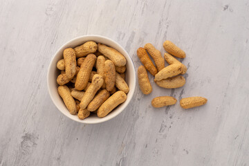 Maní tostado en un bol sobre un fondo de madera abstracto. Concepto de alimentos.