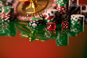 Casino. Gambling games theme.  Roulette wheel, dice and poker chips on the casino felt green table.