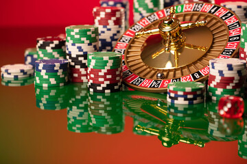 Casino. Gambling games theme.  Roulette wheel, dice and poker chips on the casino felt green table.