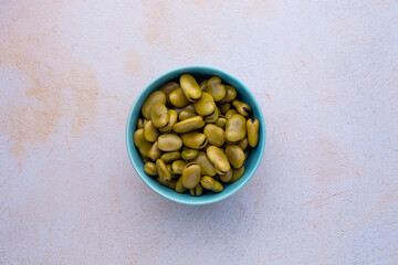 Habas hervidas servidas en un bowl con fondo claro abstracto. Concepto de alimentos.