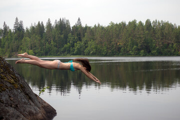Fototapeta na wymiar girl dives from a cliff