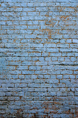 An old exterior brick wall with lovely textured paint that is cracked and peeling.