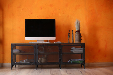 Orange living room interior with black metal Tv stand and monitor. Modern room design