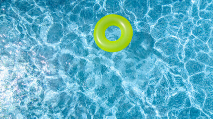 Obraz na płótnie Canvas Сolorful inflatable ring donut toy in swimming pool water aerial view from above, family vacation holiday resort background 