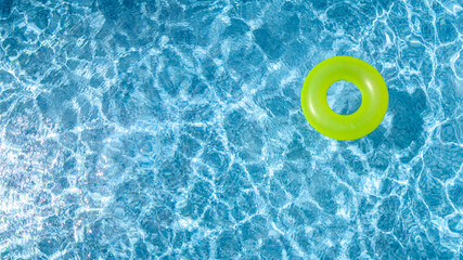 Obraz na płótnie Canvas Сolorful inflatable ring donut toy in swimming pool water aerial view from above, family vacation holiday resort background 
