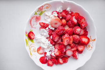 Close-up of a plate of cottage cheese with strawberries, the concept of a healthy organic breakfast, top view