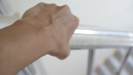 Adult hand holding a railing