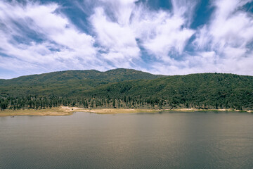 lake and mountains landscape with clouds coming towards you