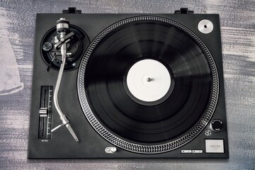 Vintage retro turntable vinyl record player with black vinyl on a table
