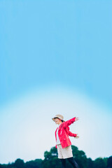 青空の下で、草原で深呼吸をする女性